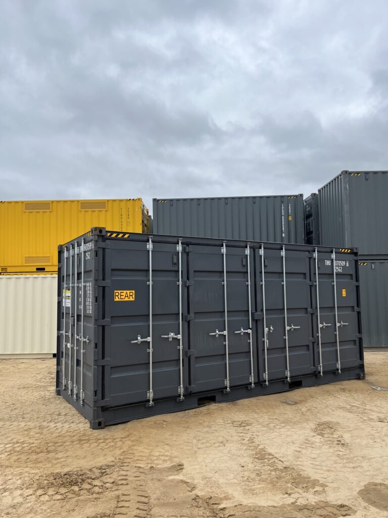 Black 20’HC Side Opening Container labeled REAR, placed on a dirt lot with stacked containers