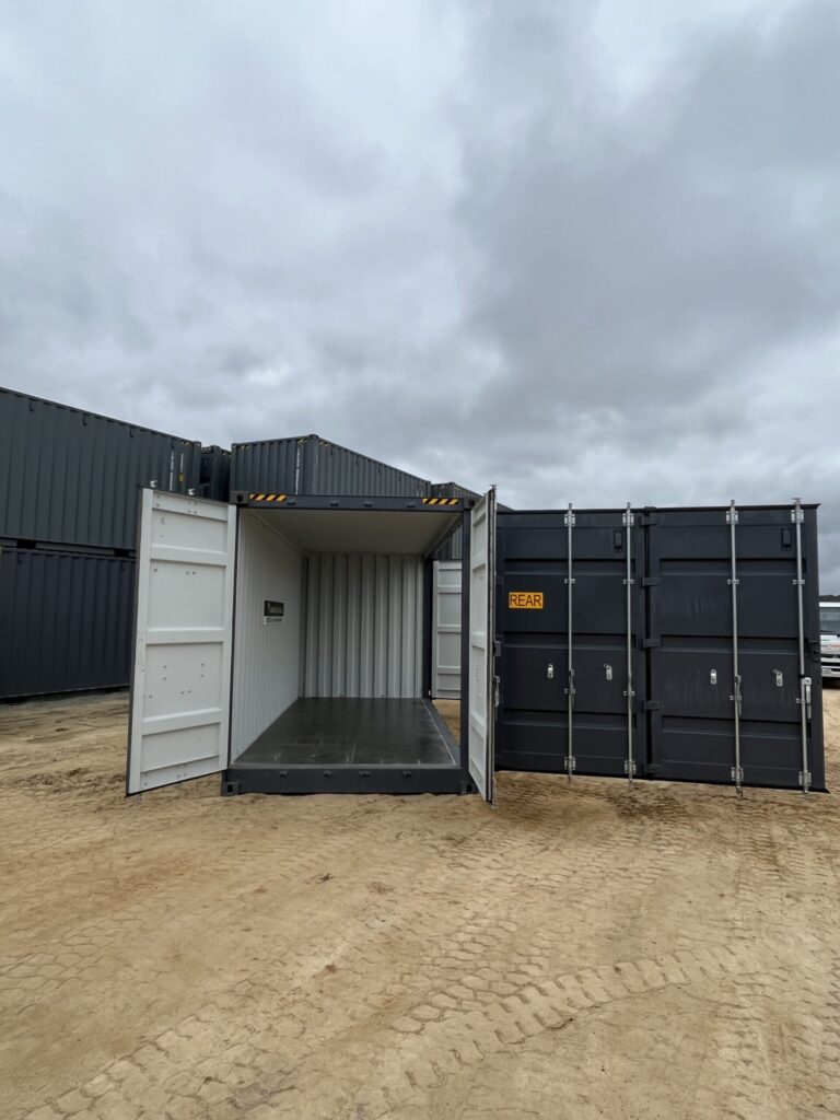 Front view of an open black 20’HC Side Opening Container on a dirt lot.