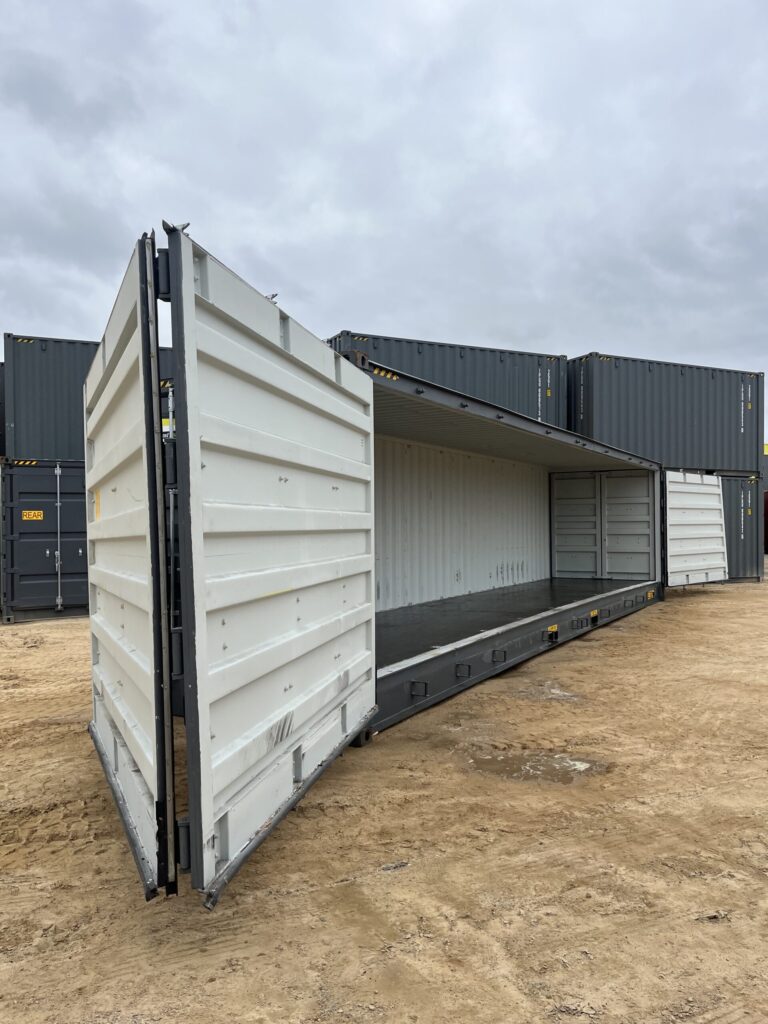 Side view of an open 40’HC Side Opening Container on a dirt surface.