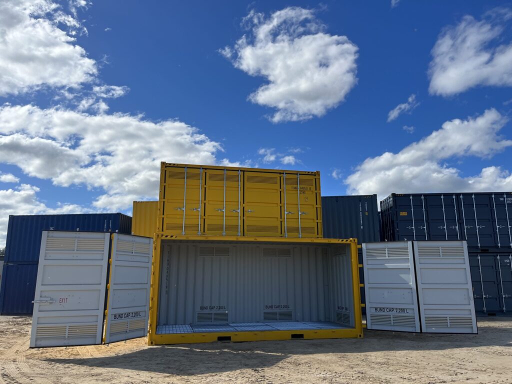 Open yellow container on sandy ground with ventilation panels and visible interi