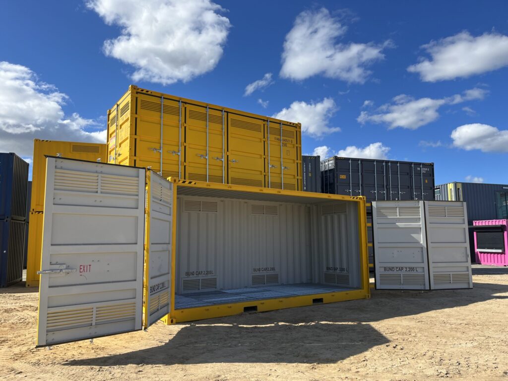 Outdoor storage facility with open and closed yellow containers under a sunny sk