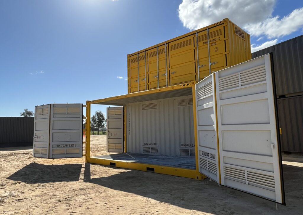 Outdoor storage yard with open and stacked yellow containers under a clear sunny