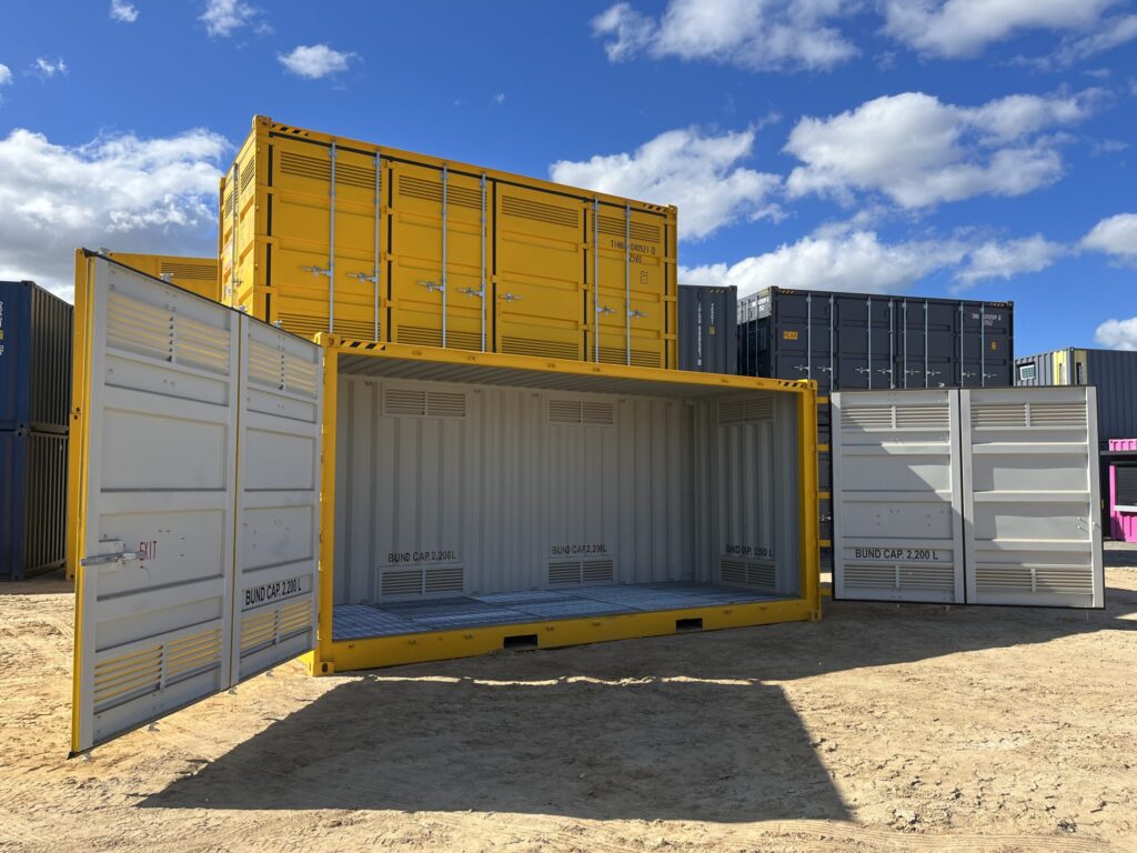 Shipping yard with yellow and blue containers arranged under a cloudy sky.