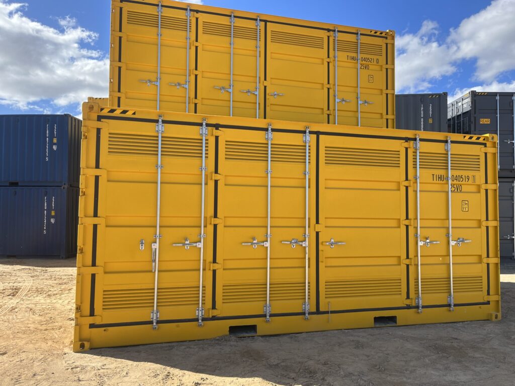 Stacked yellow shipping containers in an outdoor storage yard under a blue sky.