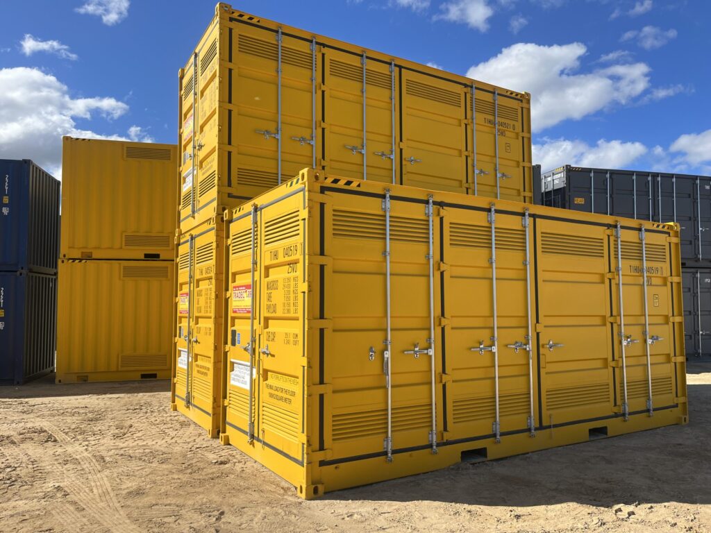 Yellow and gray shipping containers organized in a sunny outdoor area.