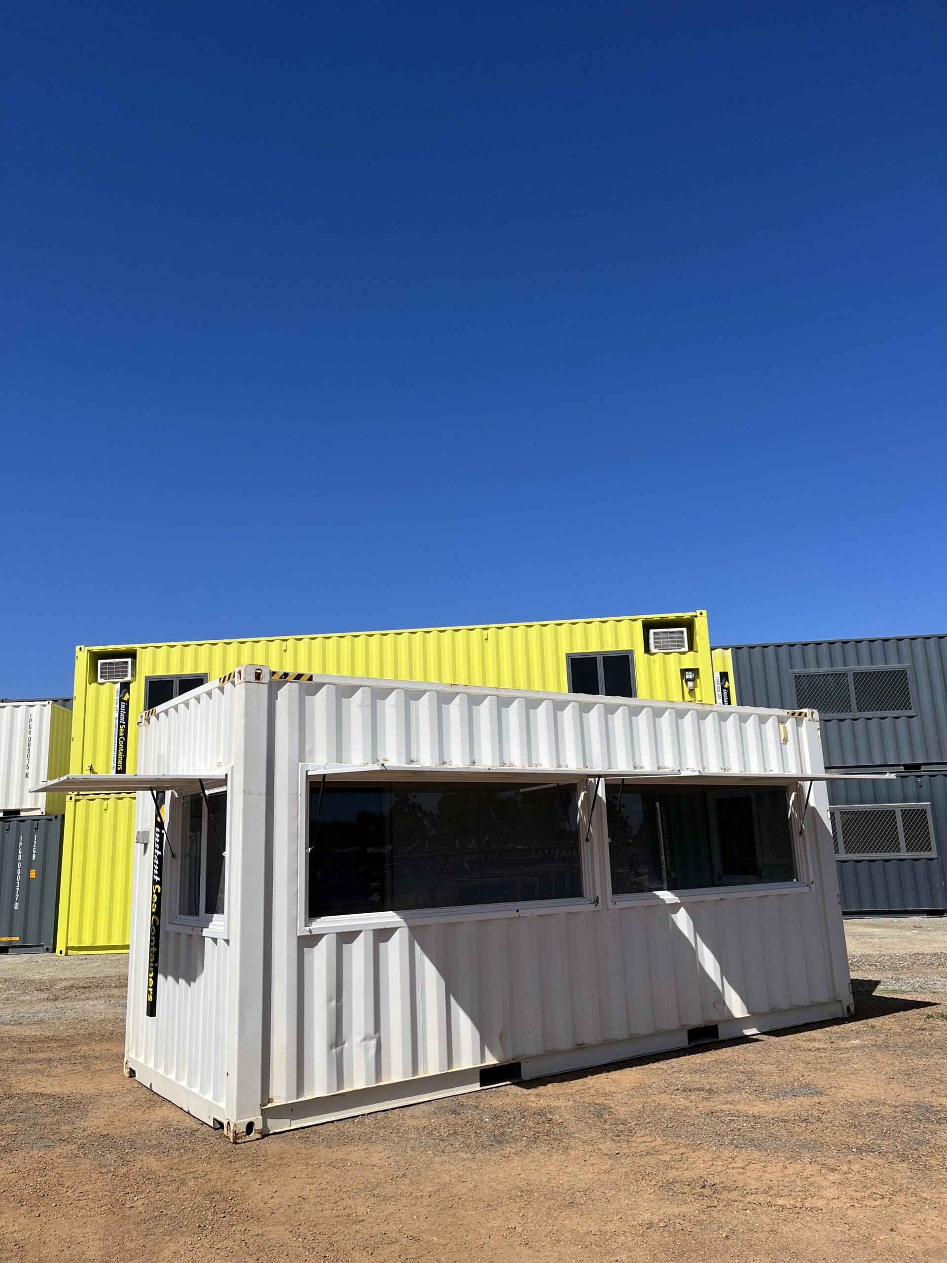 Shipping Container Control Room with a large window and awning, making it suitable for use as a mobile shop or cafe