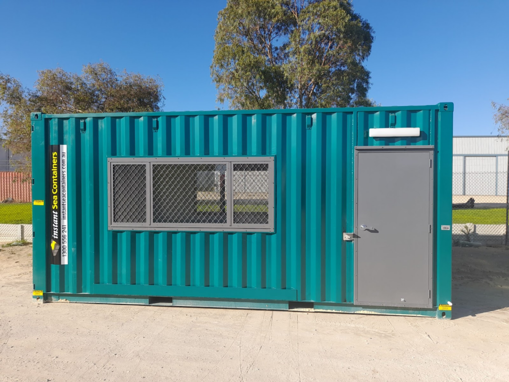 Teal shipping container modified with a security mesh window and a secure access door.