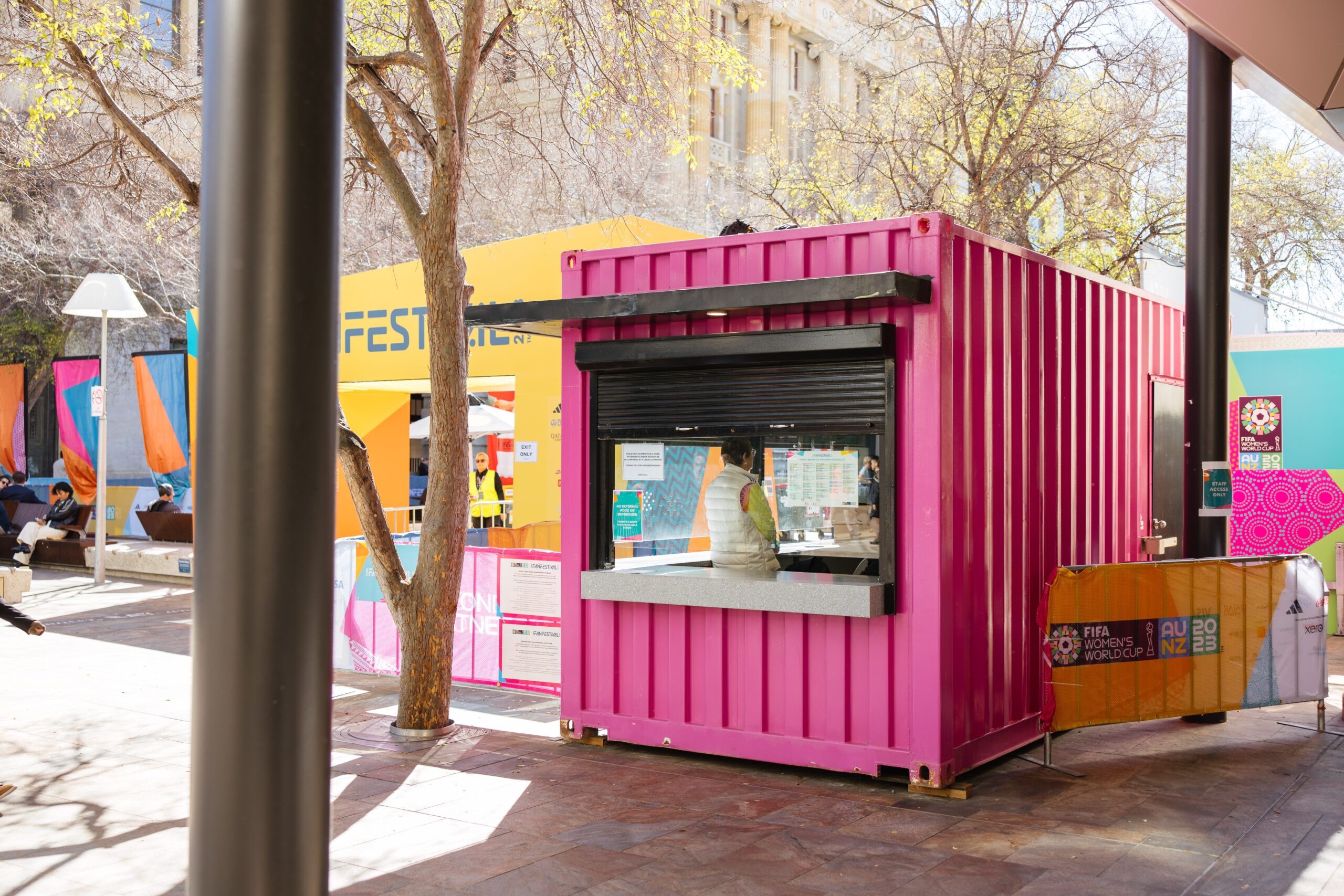 Bright pink container booth at FIFA Fan Festival 2023 with colorful decorations and visitors