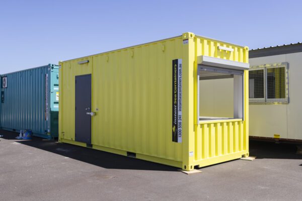 Bright yellow shipping container with window shutter on a sunny day