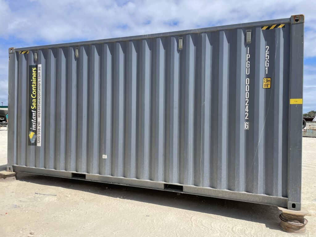 Gray Shipping Container Workshop with company branding and identification numbers.