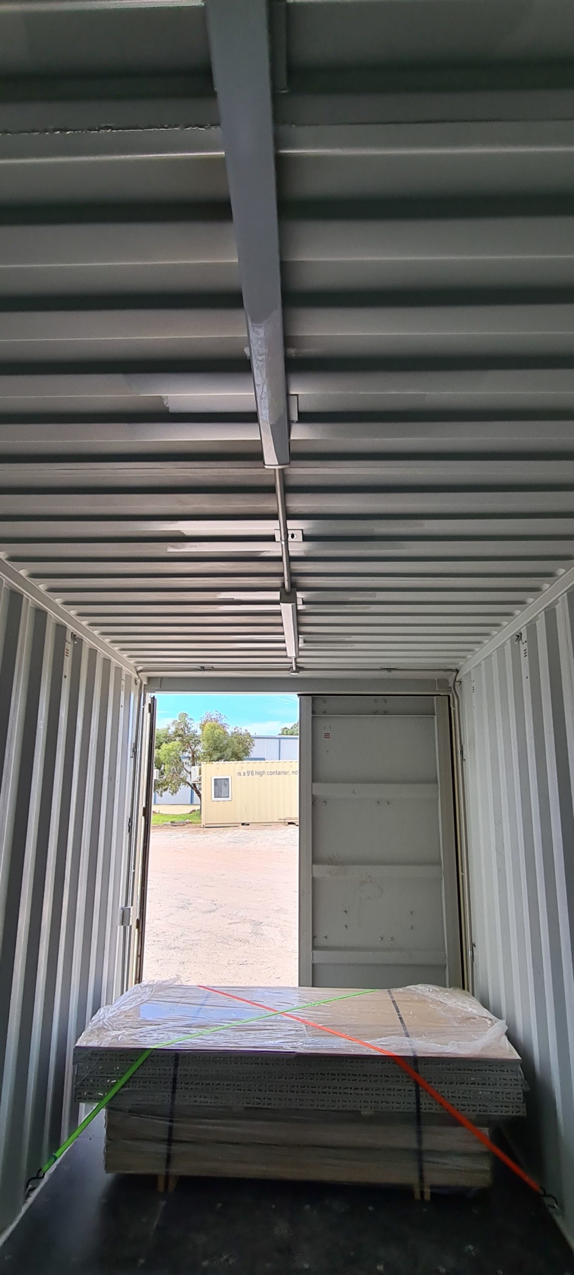 Open Shipping Container Storages viewed from inside, showing stacked materials and outside environment.