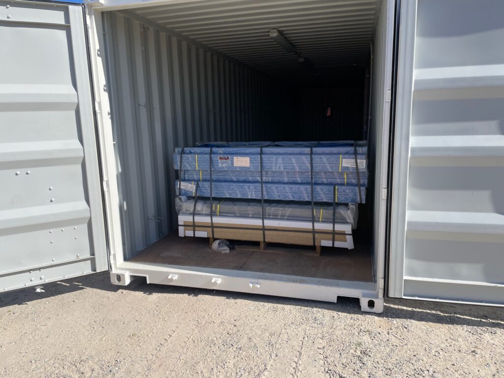 Open Shipping Container Storages with packaged goods inside, viewed from outside.