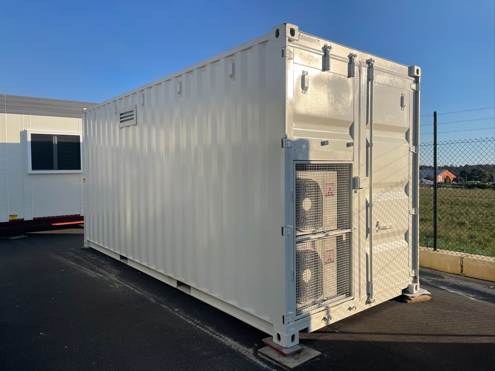 White Solar Battery Containers with external air conditioning units and a ventilation panel.